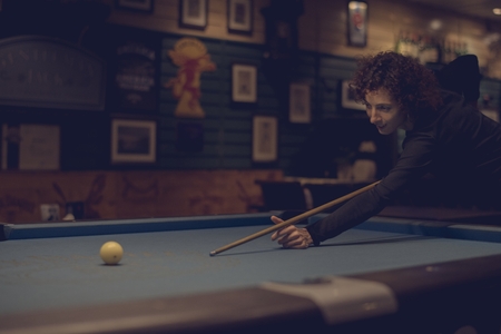 Woman playing pool at a bar