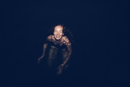 Woman swimming in the dark