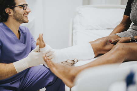 Doctor helping a patient with a fractured leg