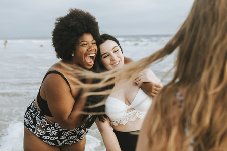 Cheerful beautiful plus size women at the beach