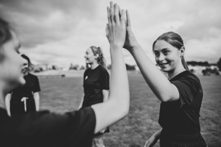 Female football players giving each other high five