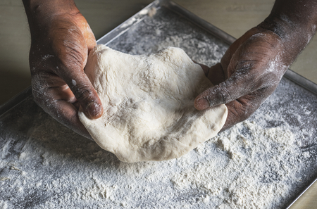 Man holding dough in the kitchen