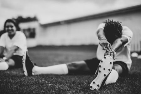 Photo pour Female football player stretching before a match - image libre de droit