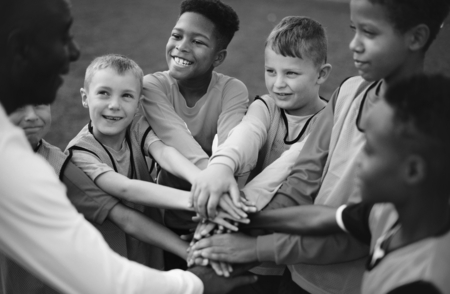 Junior football team stacking hands before a match