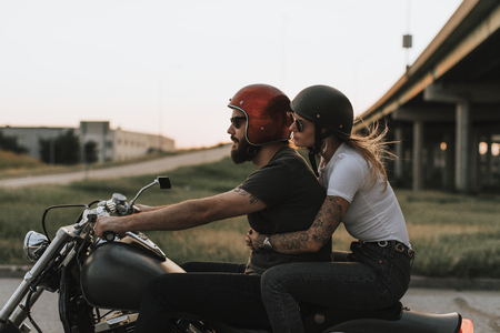 Biker couple riding down the road in the sunset