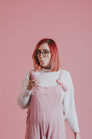 Woman sipping smoothie from a wine glass