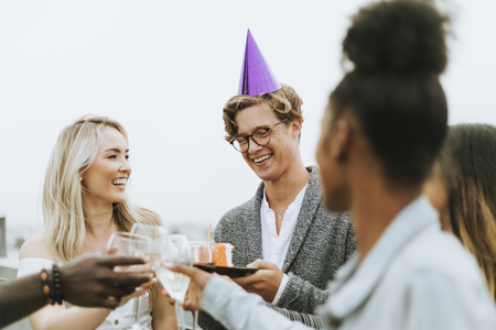 Cheerful friends celebrating at a rooftop birthday party