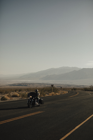 Man riding a motorcycle on a scenic route in USA
