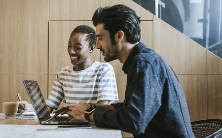 Colleagues discussing their work on a laptop