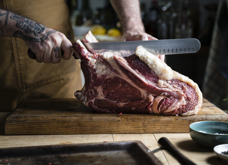 Butcher cutting a tomahawk steak