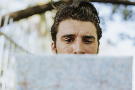 Man using a map in downtown park