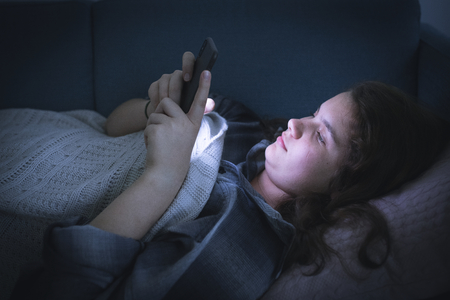 Teen girl texting in the middle of the night