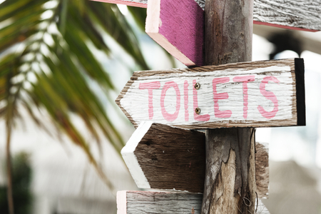 Wooden direction signage to the toilets