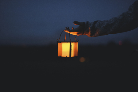Hand holding a lantern in the dark