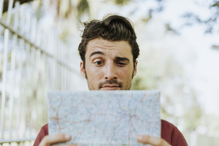 Man using a map in downtown park