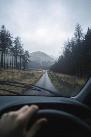 Man driving a car in the Highlands, Scotland