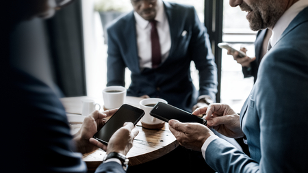 Businesspeople using their smartphones in a cafe