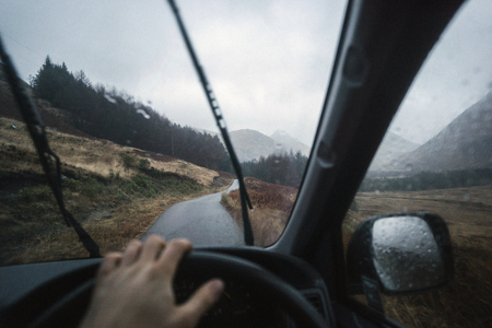Man driving a car in the Highlands, Scotland