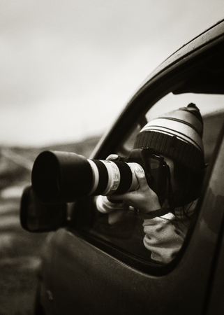 Woman taking a photo out of the car window