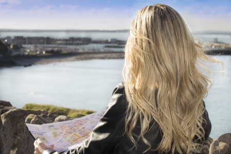 Young woman looking the landscape holding a mapの写真素材