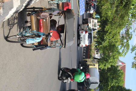 Rickshaw parked on the side of the road in front of the market