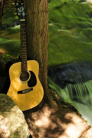 Acoustic Guitar Near Small Creek Waterfallの写真素材