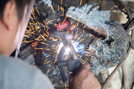 Welder working on the metal fork of a motorcycle