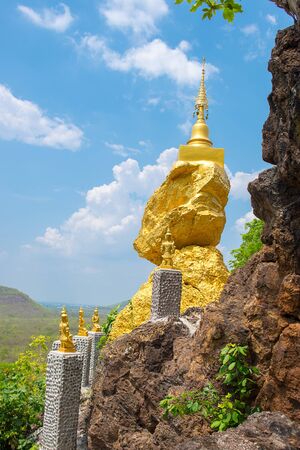 golden pagoda on golden stone with cloud and blue sky background in Lamphunの写真素材