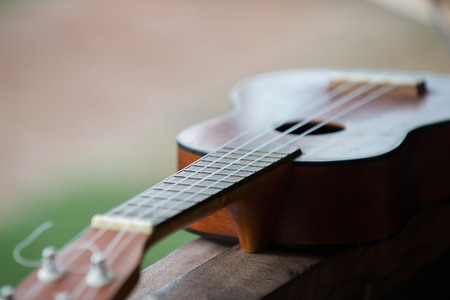 Close up of ukulele on wooden background with soft lightの写真素材