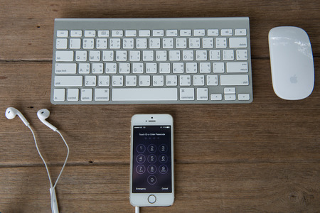 CHIANGMAI, THAILAND - June 22, 2015: New Apple Iphone5s in old wooden floor color on working table. The iPhone is the top-selling phone of any kind in some countries.のeditorial素材