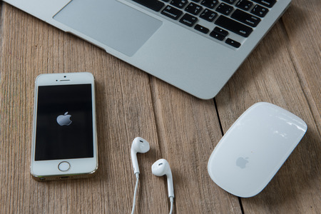 CHIANGMAI, THAILAND - June 22, 2015: New Apple Iphone5s in old wooden floor color on working table. The iPhone is the top-selling phone of any kind in some countries.のeditorial素材