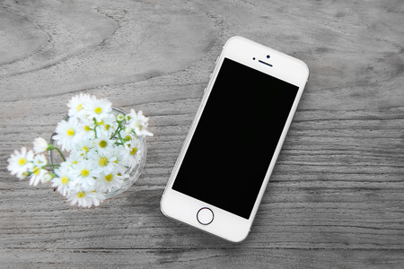 Smart phone with blank screen lying on wooden table, iphon styleのeditorial素材