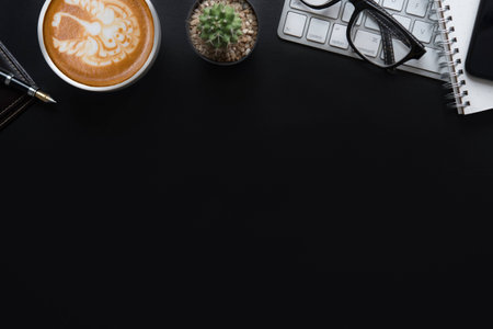 Office black desk table with computer, supplies and coffee cup. Top view with copy spaceの写真素材