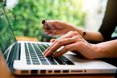 Woman shopping online Hands holding and using laptop. Online shoppingの写真素材