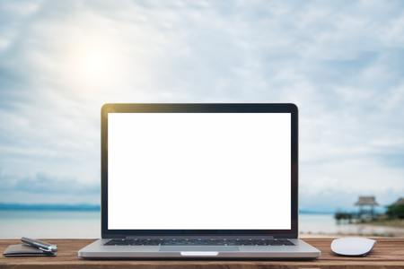 Laptop with blank screen on table of Blur summer white sand beachの写真素材