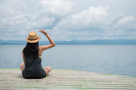 young girl with a sea-bed looking at the sea during the summer.の写真素材