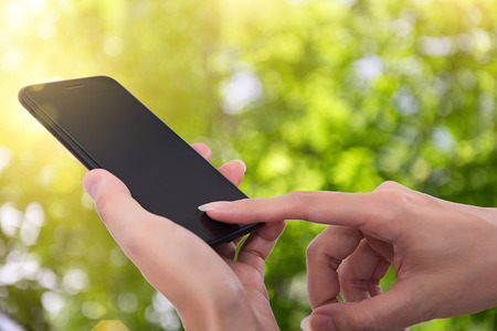 Close up of a woman using mobile smart phone outdoo,Natural Bokehの写真素材