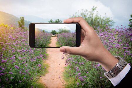 Man holding mobile smart phone taking picturesの写真素材