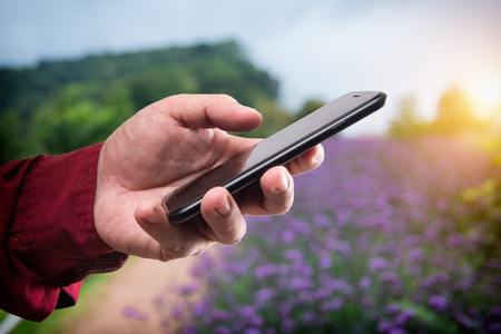 Man holding mobile smart phone in various placesの写真素材