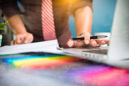 Designer Businessman hand using smart phone,mobile payments online shopping,omni channel,digital tablet docking keyboard computer in modern office on wooden deskの写真素材