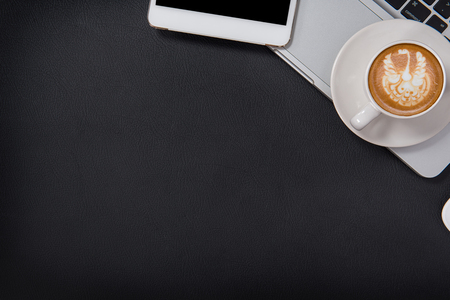 Cup of coffee, top view at the studio,Office leather desk table with coffee and supplies. Top view with copy spaceの写真素材