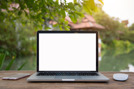 Outdoor office desk with laptop in the garden.Computer Laptop and tablet computer on the table blur background with bokeh, business technology concept ,Outdoor office desk with laptop in the garden.の写真素材
