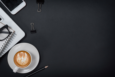 Cup of coffee, top view at the studio,Office leather desk table with coffee and supplies. Top view with copy spaceの写真素材