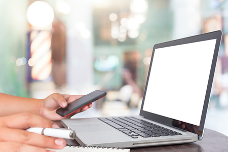 Man's hands using laptop with blank screen on desk in Barbers の写真素材