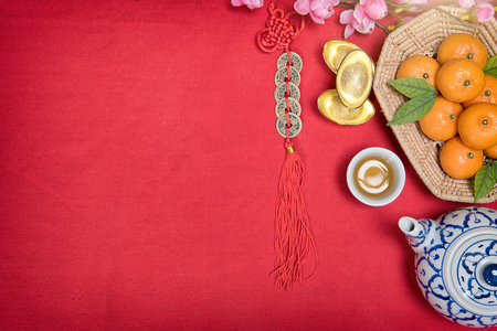 Top view accessories Chinese new year festival,leaf,wood basket,red packet,plum blossom,teapot on red background.の写真素材