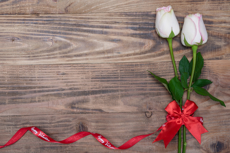 Valentines day background with rose and ribbon on wooden.の写真素材