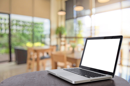 Computer notebook with a coffee shop behind the scenes Blur coffee shop, Blur restaurant sun flare effect photo.の写真素材