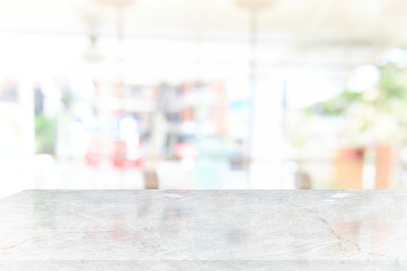 White marble table top on blur coffee shop window background. For product or foods montage.