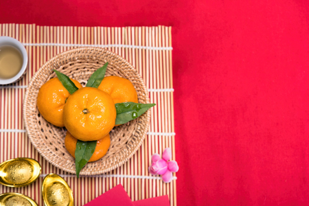Top view accessories Chinese new year festival,leaf,wood basket,red packet,plum blossom,teapot on red background.の写真素材