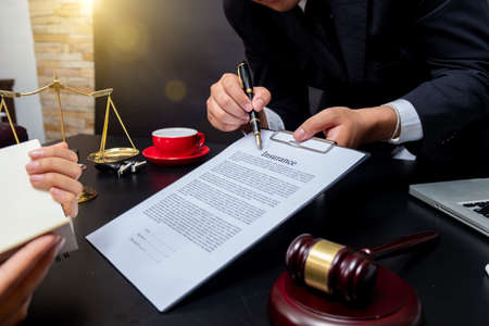 lawyer Detail of a judge sitting at his desk, studying new laws and legislation and taking notes. Selective focus.の写真素材